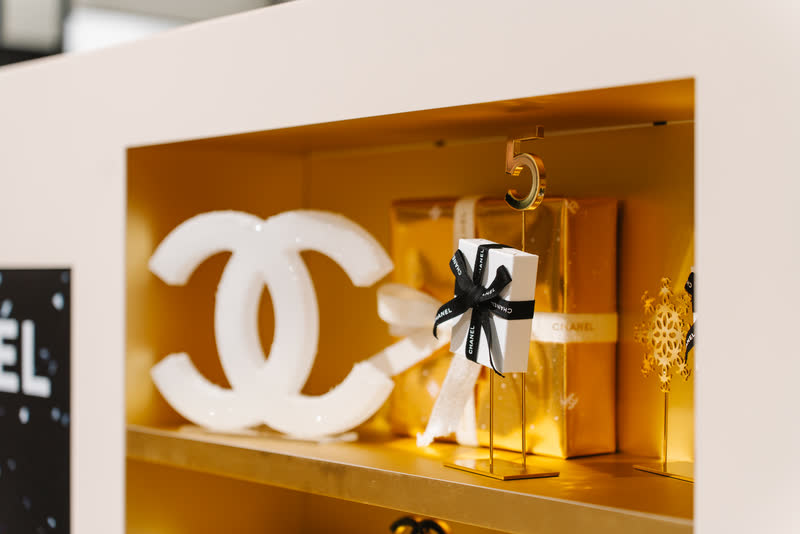 Logo Chanel na złotej półce z prezentami